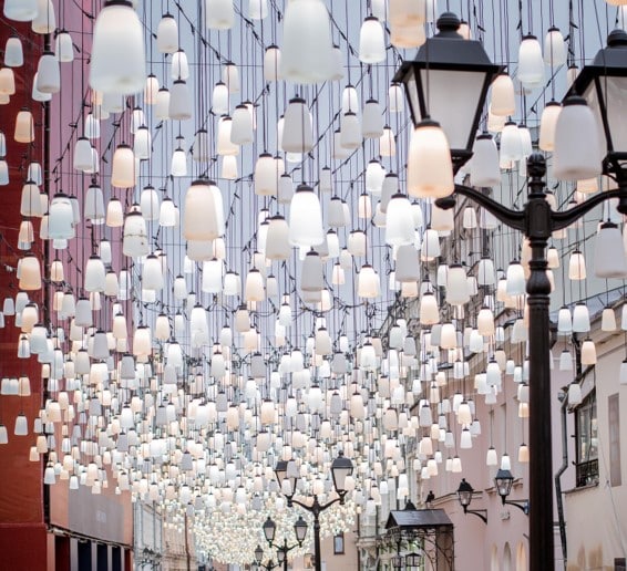 Photo of hundreds of lit lanterns hanging above a street.