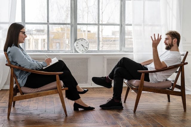 Man and woman sitting opposite each other in a therapy session.