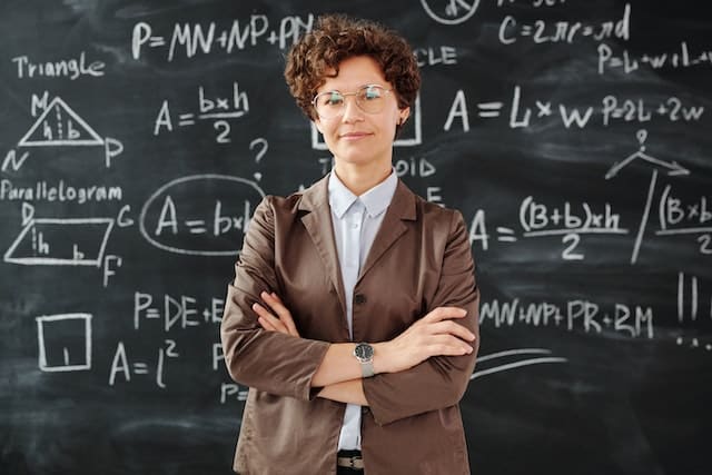 Why spiritual awakening happens: smiling female teacher in front of a blackboard.