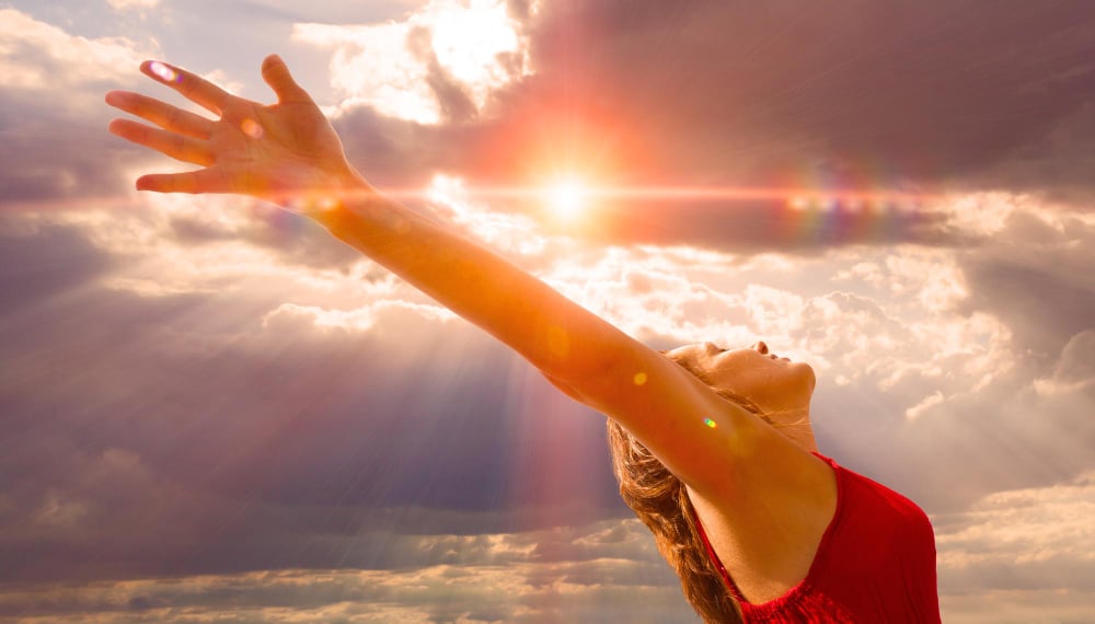 Why am I having a spiritual awakening? Women with arms thrown up to the sun.