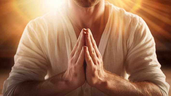 Manifestation: Image of man with hands in prayer and bright gold light behind him.