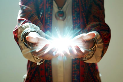 How manifestation works: image of a pair of hands conjuring a ball of light between them.